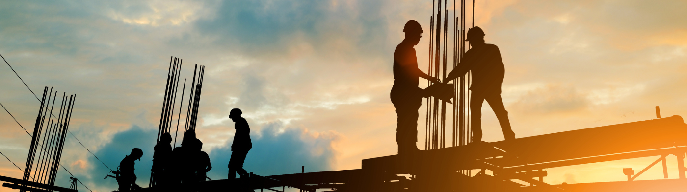 construction workers building at sunset