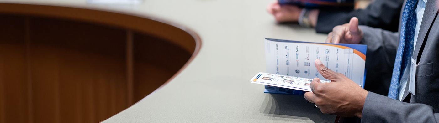 Close-up of a business professional holding an open document at a conference table